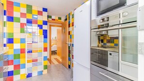 A kitchen with a colorful tile backsplash, a microwave, and a built-in oven. - Your Ideal Base to explore Zaragoza`s delights (Zaragoza)