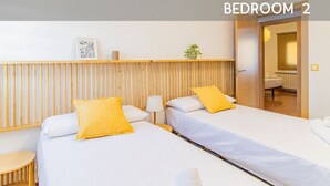 A hotel bedroom with two beds, a wooden headboard, a small table, and a plant. - Your Ideal Base to explore Zaragoza`s delights (Zaragoza)