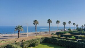 A coastal promenade with palm trees, a clear sky, and a view of the sea. - VACATION HOME SUN & BEACH - LEMONS APARTMENT (Capo d'Orlando)