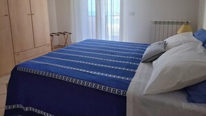 A bedroom with a bed, a wardrobe, and a window with curtains. - VACATION HOME SUN & BEACH - LEMONS APARTMENT (Capo d'Orlando)