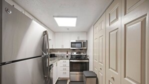 A compact kitchen with a refrigerator, microwave, stove, and oven. - King Bed, 5 min walk Truist Park | The Battery (Smyrna)