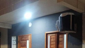 A building with a dark facade, a wooden door, and a window with wooden shutters. - Loft Pajuçara (Maceio)