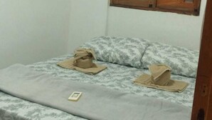 A small room with a bed, a window with wooden shutters, and an air conditioning unit mounted on the wall. - Loft Pajuçara (Maceio)