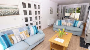 A modern living room with two sofas, a coffee table, and a view of the outdoors. - Whitfield P1 (Yarmouth)