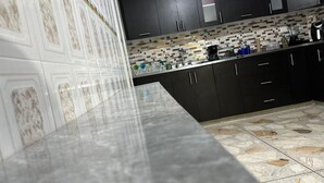 A kitchen with dark cabinets, a tiled backsplash, and a marble countertop. - Spacious 3BR in Central Medellín • Home Theater • Near Laureles & Poblado
 (Medellín)