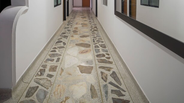 A hallway with white walls, stone-patterned flooring, and a series of doors with mirrors. - Spacious 3BR in Central Medellín • Home Theater • Near Laureles & Poblado
 (Medellín)