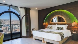 Ein modernes Schlafzimmer mit einem großen Bett, Blick auf die Stadt durch ein großes Fenster und einem einzigartigen, grünen Bogen über dem Bett.