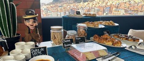 Un bufé de desayuno con diferentes alimentos y vista a la ciudad.
