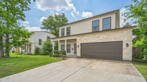 A two-story house with a stone facade and a garage. - The Krakow | Sleeps 16 (Houston)