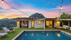 A modern house with a pool, outdoor seating, and a mountain view. - Designer Retreat w/ Pool, Firepits, Panoramic Views The Lake House at Malibu (Agoura Hills)