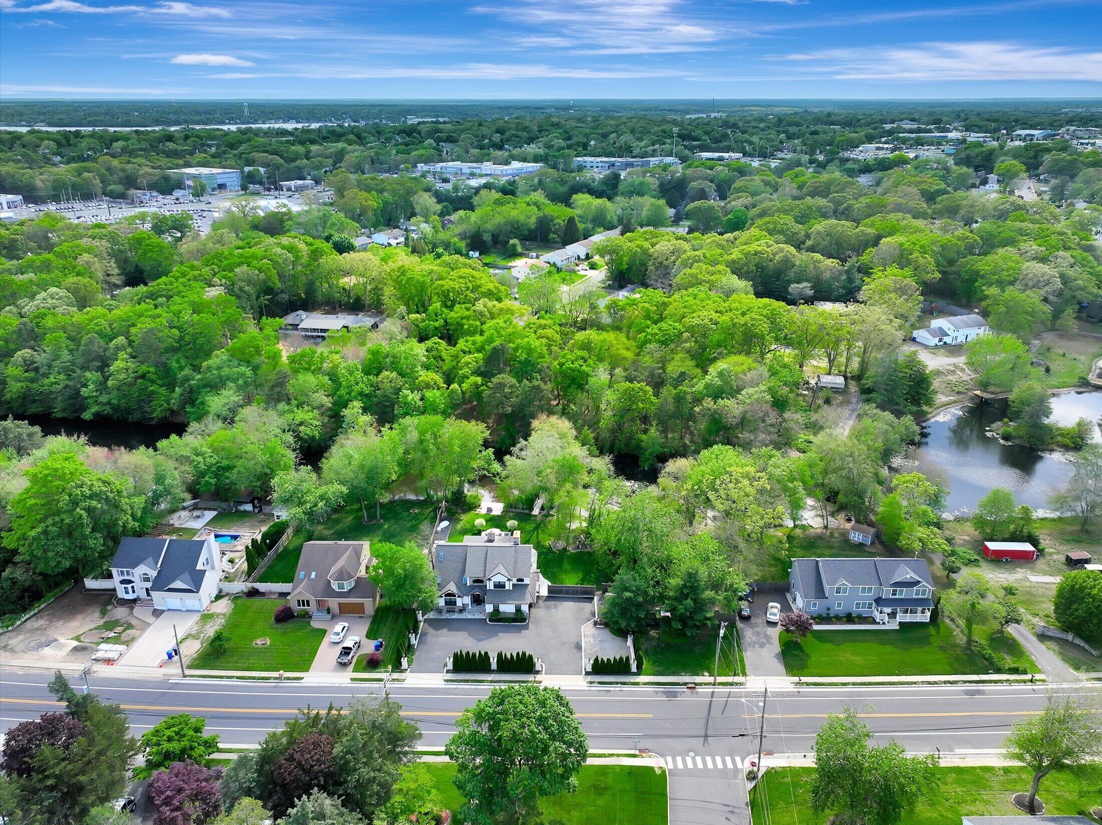 A residential area with houses, a river, and a clear sky.
