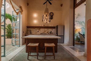 Modern kitchen with a central island, gas stove, sink, and refrigerator, adjacent to a dining area.
