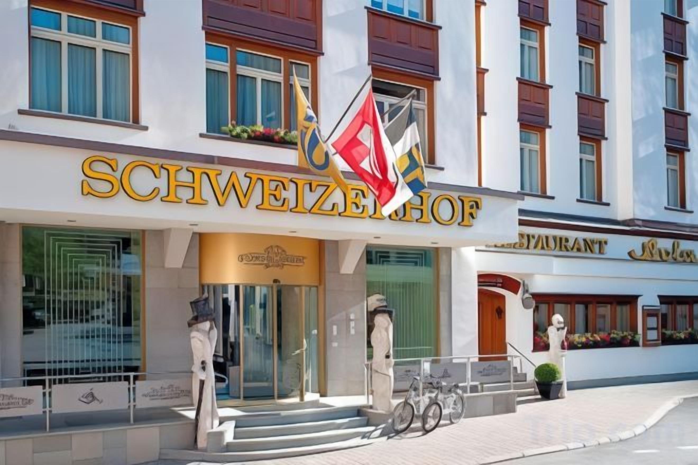 A hotel entrance with a sign reading 'SCHWEIZERHOF' and a flag.