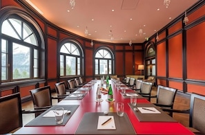 A conference room with a long table, chairs, and large windows.