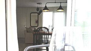 Un coin repas avec une table, des chaises et un verre de vin.