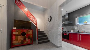 Una cocina moderna con armarios rojos, horno integrado y ventana con vistas.