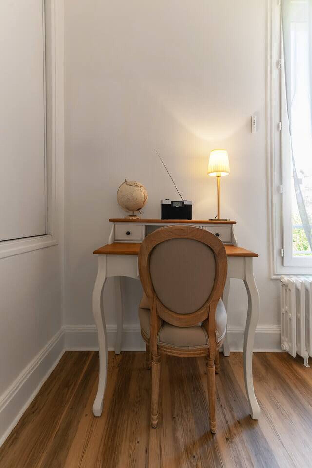 En studie med en trästol, en jordglob, en radio och en lampa.