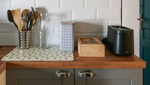 Eine Küchenarbeitsplatte mit einem Messerblock, einem Glasbehälter, einer verzierten Schachtel, einer Holzkiste und einem Toaster.