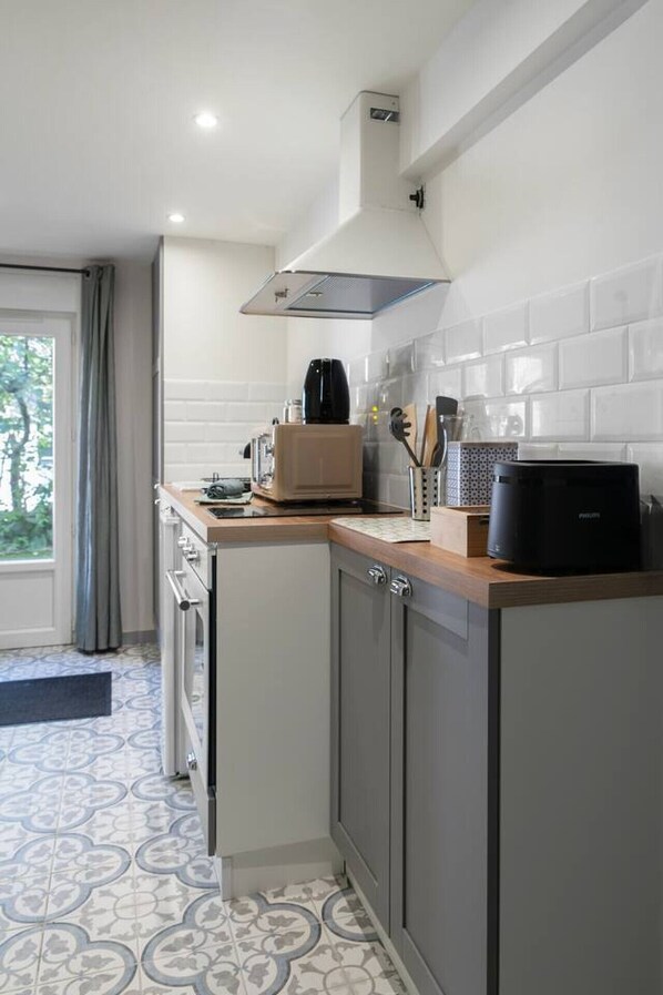 A compact kitchen with a built-in oven, a coffee maker, and a microwave.