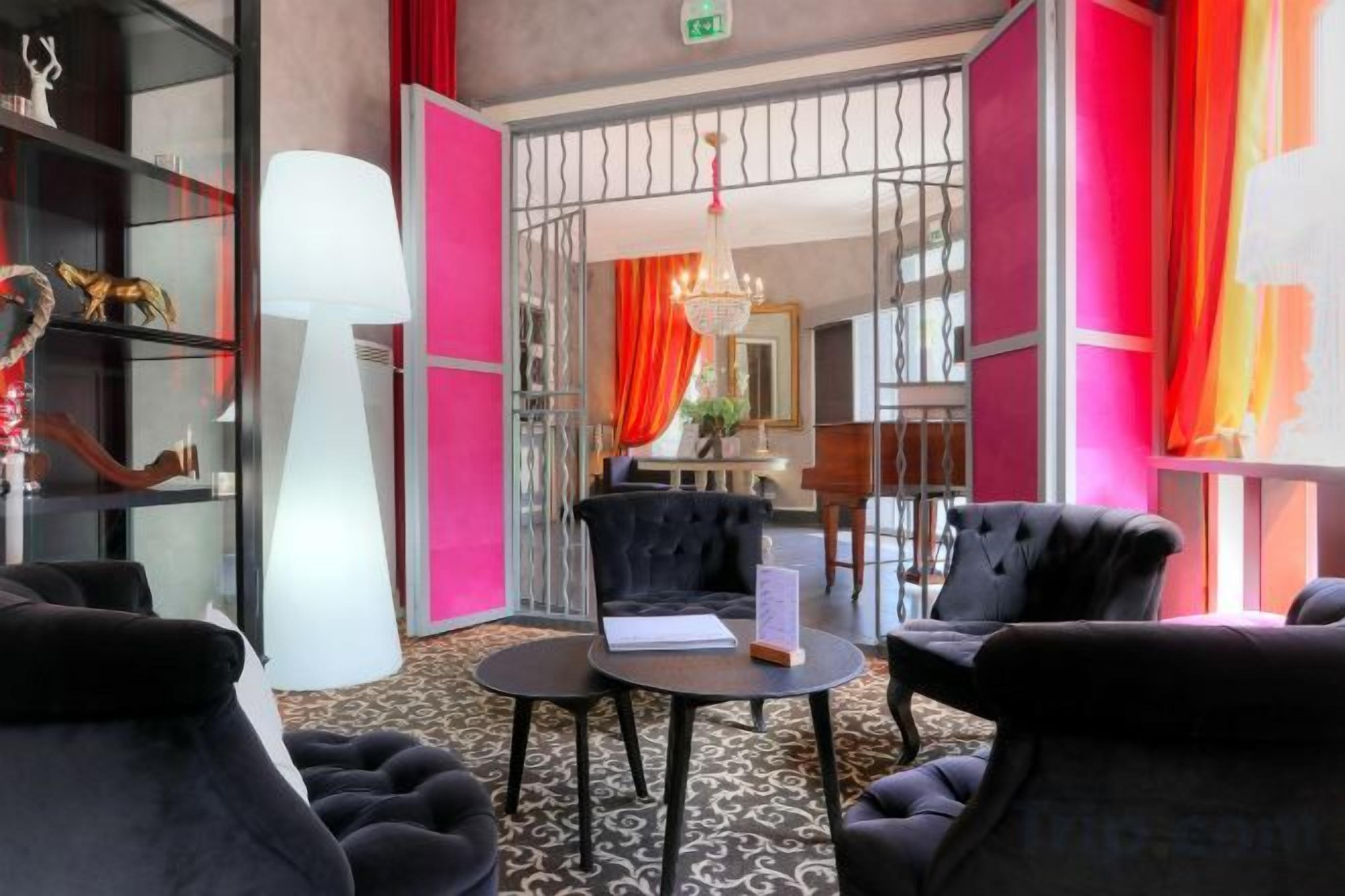 Un vestíbulo de hotel con una zona de estar, un candelabro y vistas de la habitación.