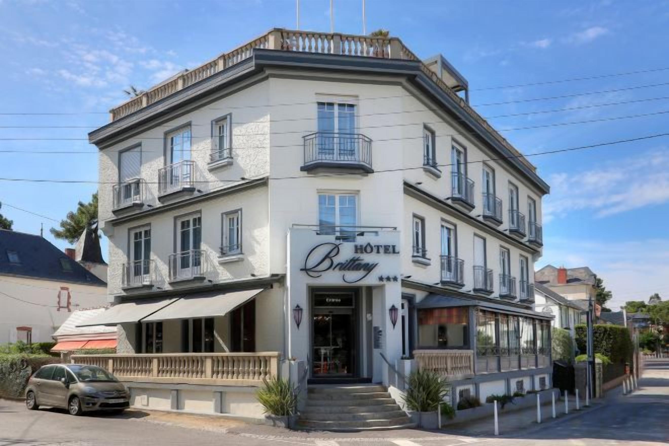 Un edificio en esquina con un cartel que dice 'HOTEL Brittany'.