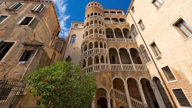 A historic building with multiple arches and a central tower. - Hotel Airone (Venice)