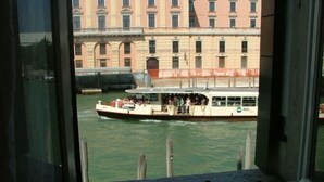 A boat with passengers on a canal, viewed from a window overlooking a building with classical architecture. - Hotel Airone (Venice)