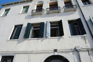 A building with multiple windows, some with shutters, and a balcony. - Hotel Airone (Venice)