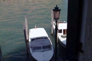A boat docked at a pier with a lamp post nearby. - Hotel Airone (Venice)