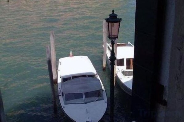 A boat docked at a pier with a lamp post nearby. - Hotel Airone (Venice)