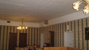 A dining area with a chandelier, striped wallpaper, and a wooden podium. - Hotel Airone (Venice)
