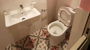 Un baño con lavamanos, inodoro y espejo.