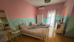 Un dormitorio con dos camas, una mesita, un armario y un escritorio.