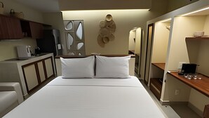 A hotel room with a bed, a desk, a coffee maker, and a wall-mounted decorative piece. - Prime Soul Brooklin (Sao Paulo)