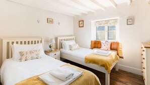 Un dormitorio con dos camas, una ventana y un aparador.