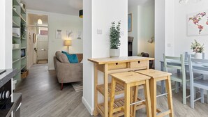 A modern kitchen with wooden stools, a dining table, and a potted plant. - Pass the Keys | Stunning 3-bed Retreat in the Heart of York (York)