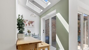 A modern kitchen with a wooden table, potted plants, and a world map artwork. - Pass the Keys | Stunning 3-bed Retreat in the Heart of York (York)