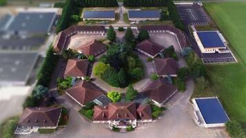 An aerial view of a hotel with multiple buildings, parking areas, and green spaces.