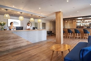 Un espace d’accueil comprenant un bar, des sièges et un comptoir de réception.