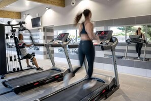 A gym with treadmills, exercise equipment, and a mirrored wall. - Kyriad Sens (Sens)