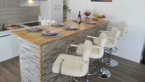 Une cuisine moderne dotée d’un îlot central, de tabourets de bar et d’un coin repas.