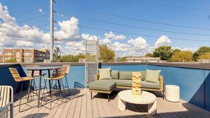 Una terrazza panoramica con area salotto esterna, piscina e vista sulla città.
