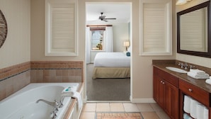 Een hotelbadkamer met een bad, een wastafel en een spiegel.
