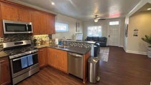 A modern kitchen with wooden cabinets, stainless steel appliances, and a central island. - Sunny condo by the Bay! [unit B] (San Diego)