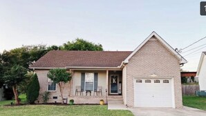 A single-story house with a brick facade, a front porch, and a garage.