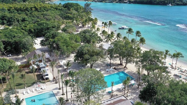 A resort with a swimming pool, beach, and ocean views.
