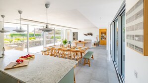 A modern kitchen with a large island, dining area, and a view of the outdoors. - Heath House, Thorpeness (Thorpeness)
