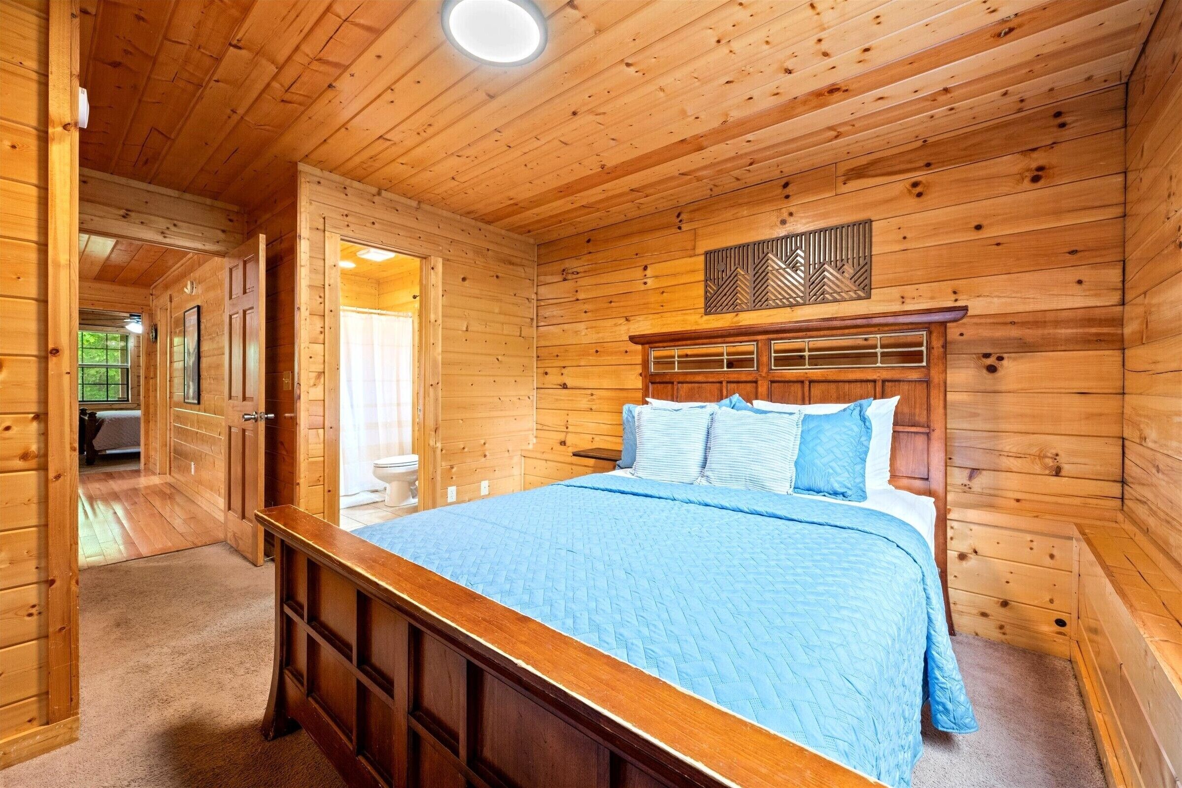 Une chambre à coucher dans une cabane en bois, avec un lit, une table de chevet et une fenêtre.