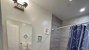 Une salle de bain moderne avec un lavabo blanc, des toilettes et un espace douche.