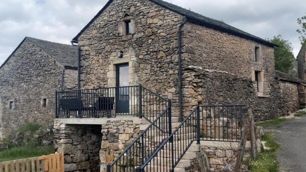 A stone building with a balcony and a staircase leading to a door. - Le P'tit Pelet, a house in the heart of the rocks (Fraissinet-de-Fourques)